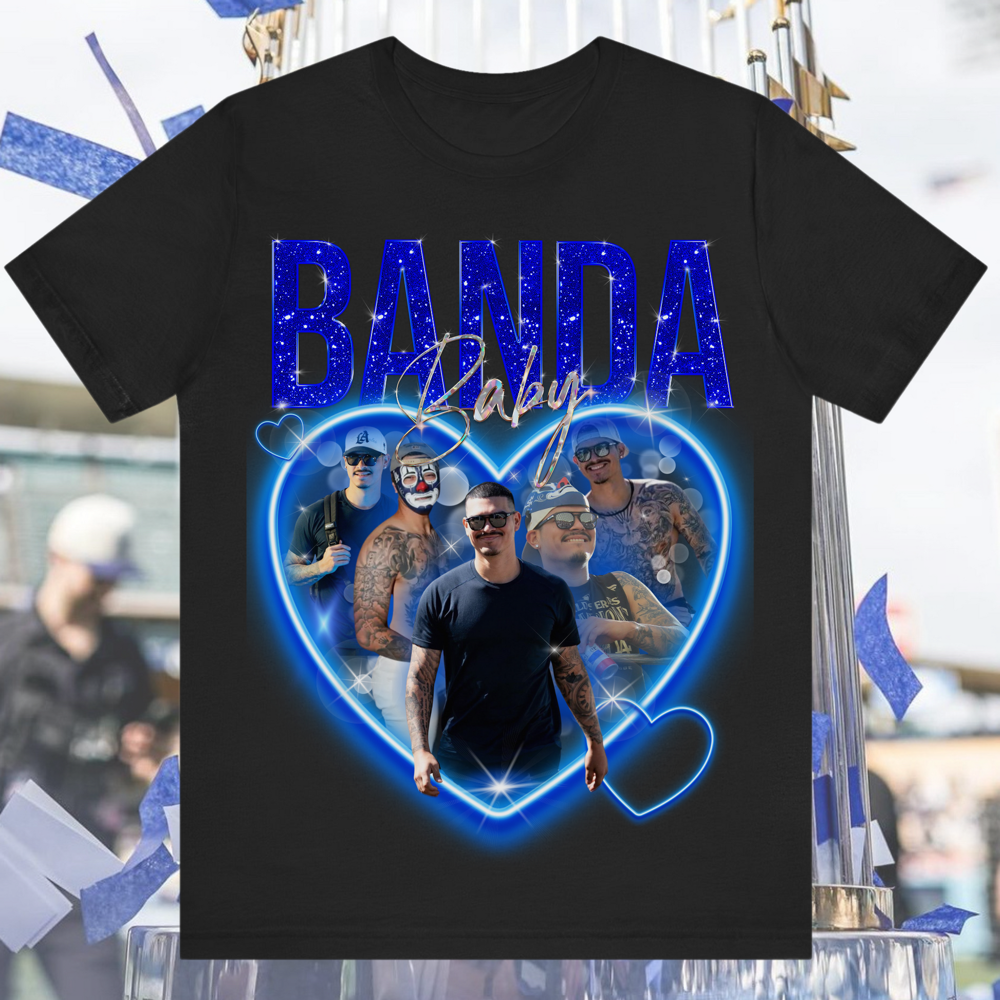 “Black t-shirt featuring Banda Baby design with blue glitter text, heart-shaped collage of tattooed man in sunglasses, and holographic style details”